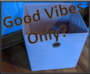 A light pink box on wood floor that shows a text at the top: "Good Vibes only?"